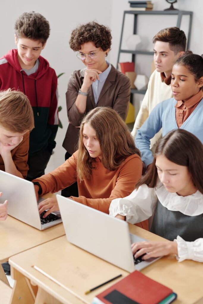 Crafting Captivating Headlines: Your awesome post title goes here Group of teenagers in a classroom collaboratively working on laptops, fostering team learning.